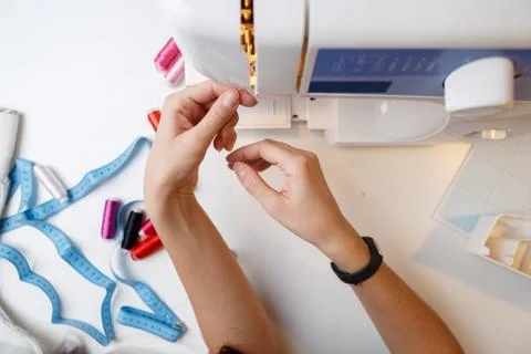 Girl inserts thread in sewing-machine 스톡 사진