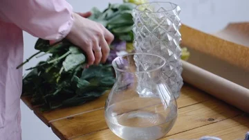 Girl inserts yellow eustomas into a vase of water 動画素材 85969346