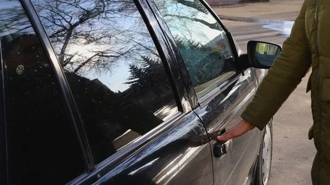 The girl in the jacket opens the door and sits in the car Stock Footage