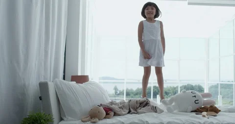 Girl jumping on the bed Stock Footage 100944941