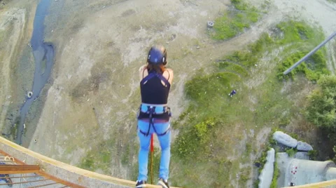 Girl jumping from the bridge facing forward with his arms folded Stock Footage 53350033