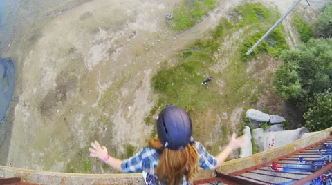 Girl jumping from the bridge facing forward his arms Stock Footage 53350309