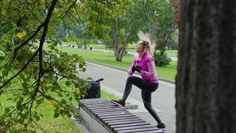 Girl jumping on a park bench Stock Footage 196286233