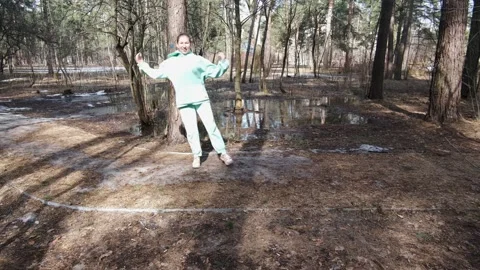 Girl jumping through the forest with a side step Stock Footage 182054602