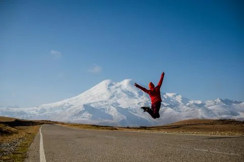 The girl jumps to the top with a view of Elbrus Photos