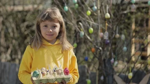 Girl keeps decorated Easter eggs in the palms Video stock 232731306