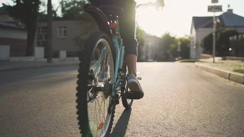 Girl Kid Riding Bike in Summer in City at Beautiful Sunset Stock Footage