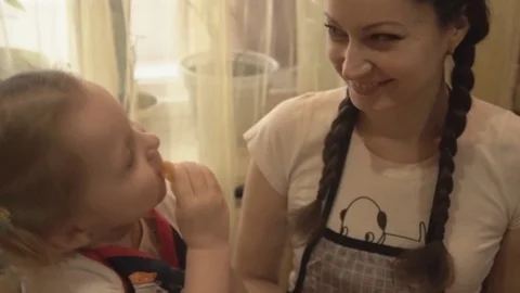 The Girl in the Kitchen With my Mom Eats a Yellow Pepper Stock Footage 74164865