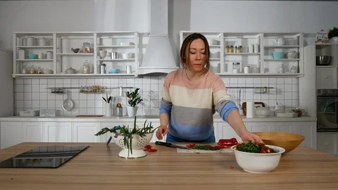 Girl in the kitchen preparing a salad Vidéo 126357220