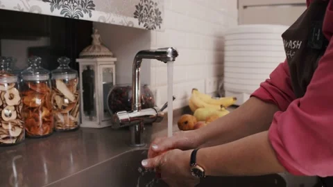 A girl in the kitchen washes fruit under the tap Stock-Footage 200946356