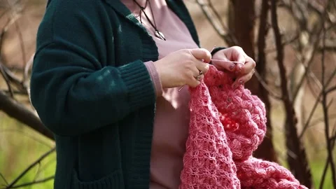 A girl knits a shawl while sitting in a park Stock Footage 309233266