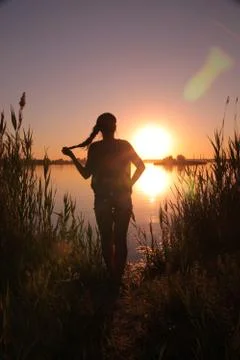 Girl at the lake at sunset Stock Photos