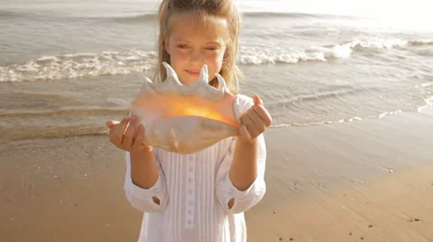 Girl with large shell on beach Stock Footage 43623356