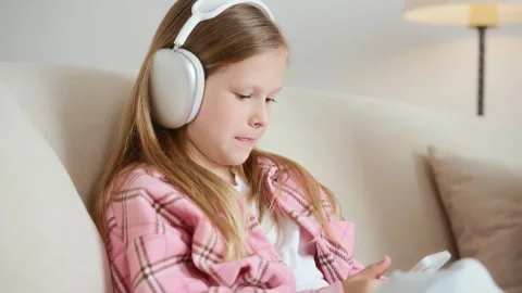 Girl laughing while using smartphone in headphones Stock Footage 312286303