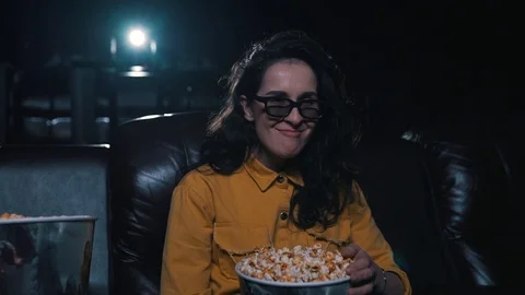 The girl laughs and eats popcorn in the cinema Stock Footage 94670587