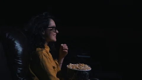 The girl laughs and eats popcorn in the cinema Stock Footage 94670618