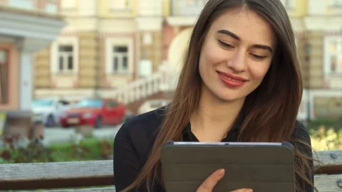 Girl laughs joyfully while watching something funny on her tablet Stock Footage 311944104