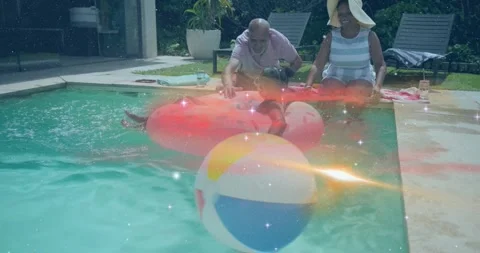 Girl leaning back causing waves as grandparents guiding donut float and showing Video stock 320482220