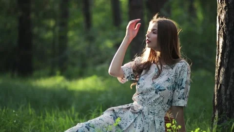 Girl leans on big tree while relaxing in park. Female student spending time in Stock Footage 147642015