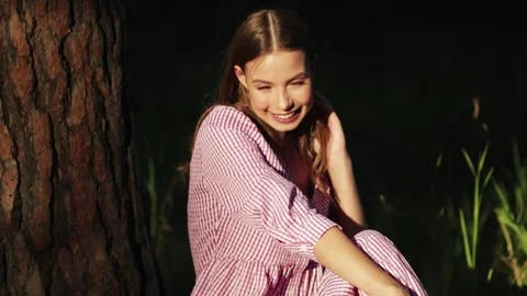 Girl leans on big tree while relaxing in park. Female student spending time in Stock Footage 149544579