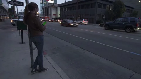 Girl Leans on Post Using Smart Phone Mobile in Downtown with Green Screen. Stock Footage 50000221