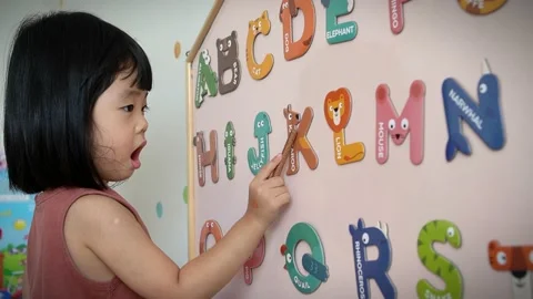 A girl is learning the alphabets on the board Stock Footage 219849008