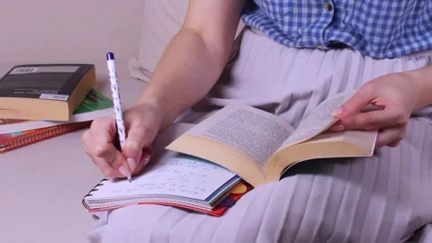 Girl learning lessons, looking for information in book by turning pages. Hom Stock Footage 151050552