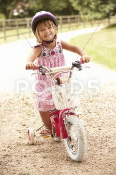 Girl Learning To Ride Bike Wearing Safety Helmet Stock Photos