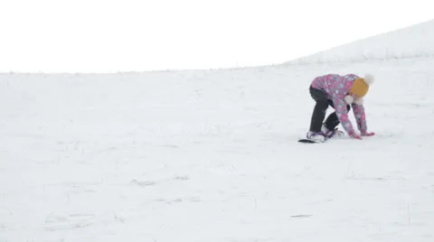 Girl learning to ride a mountain slope on a snowboard Stock Footage 59140141