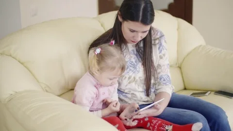 Girl learning to use a tablet with her mum. 動画素材 79713126