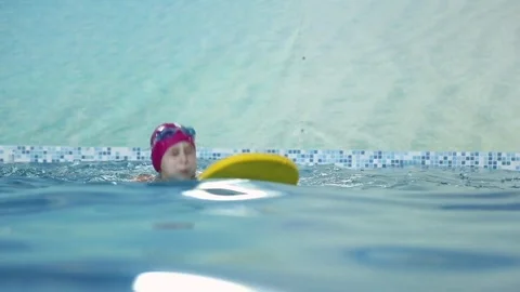 Girl learns to swim in the pool Stock Footage 70819330