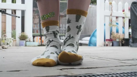 Girl legs with a plaster wearing funny socks Stock Footage