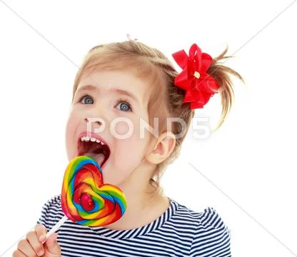 Girl licks candy on a stick Stock Photos