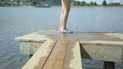 Girl in a life jacket jumping into water Stock Footage 99899853