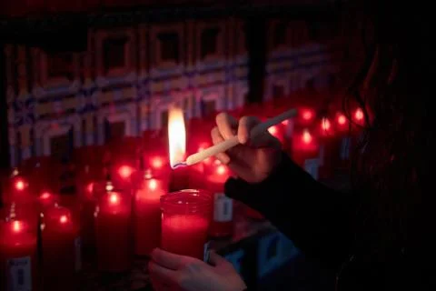 Girl lighting red candle in Olvera hermitage Stock Photos