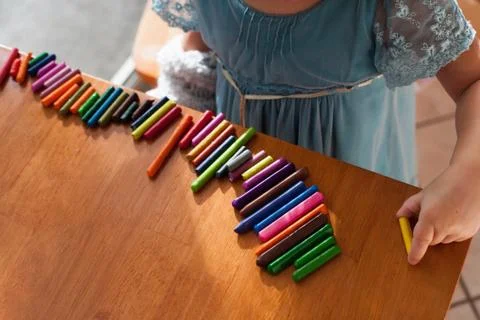 Girl lining up crayons in a row Stock Photos