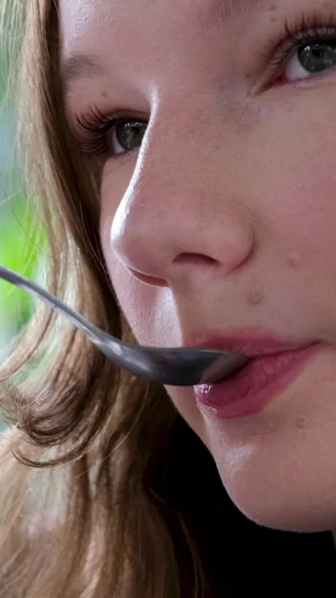 The girl with lipstick makeup eatsfrom a spoon. Close up. Stock Footage 294803534