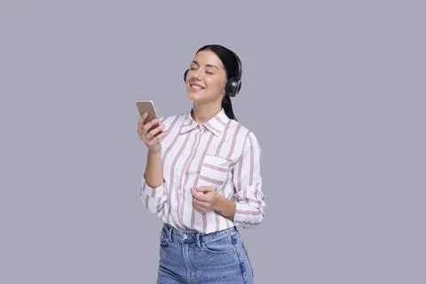 Girl Listening to Music from Phone Enjoying It. Girl Listening Music with Stock Photos