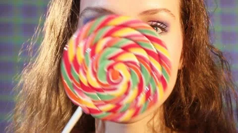 Girl with a lollipop shows different facial expressions Stock Footage