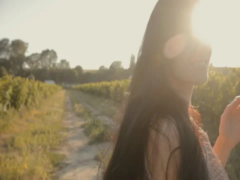 Girl with long hair walking along the rows of vineyards Stock Footage 59387141