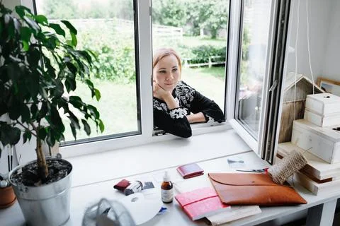 Girl looked through the window into the workshop Stock Photos