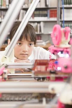 Girl looking at 3D printer. Stock Photos