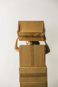 Girl looking away while stacking boxes against white background Foto stock