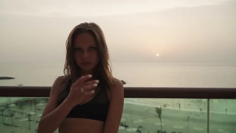 Girl looking at the camera on the background of the sunset. 스톡 동영상 167734916