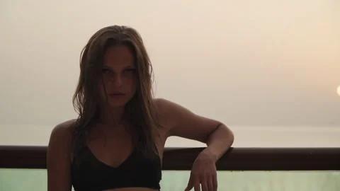 Girl looking at the camera on the background of the sunset. 스톡 동영상 167734962