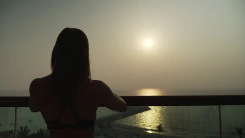 Girl looking at the camera on the background of the sunset. Видео 167736976