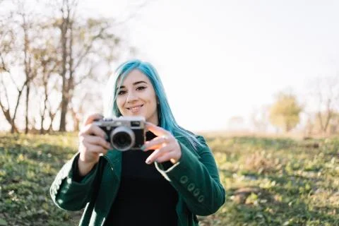 Girl looking into a camera while holding photo camera Stock Photos