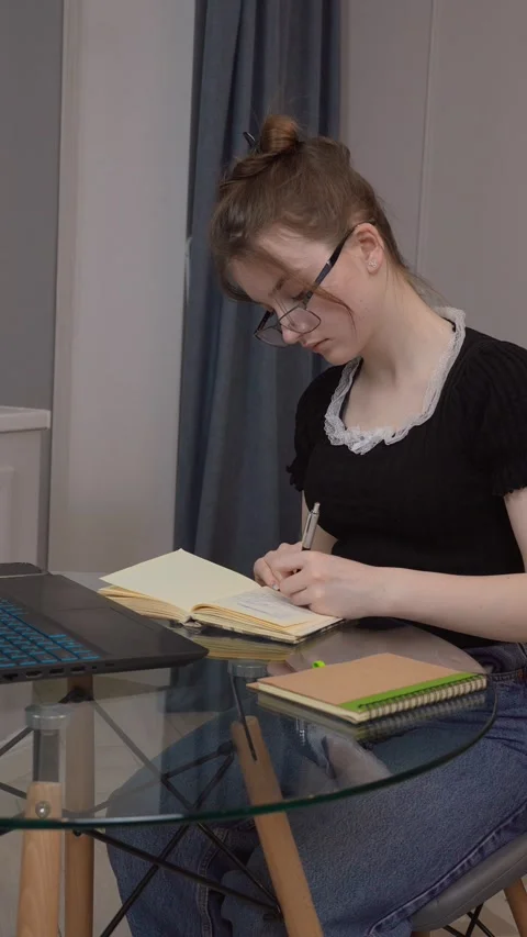 Girl looking at computer screen listening online lecture improve language skills 動画素材 311808162