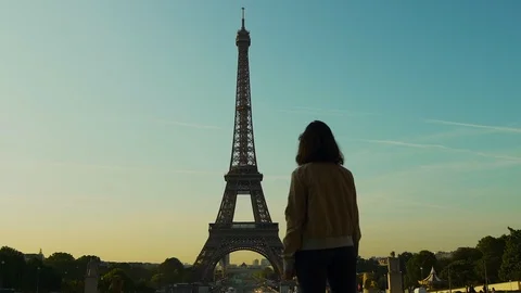 Girl looking at Eiffel tower at sunset orange blue sky in Paris during the Stock Footage 119357409