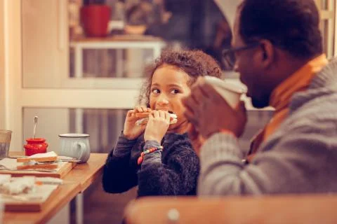 Girl looking funny while feeling hungry and biting her sandwich Foto stock